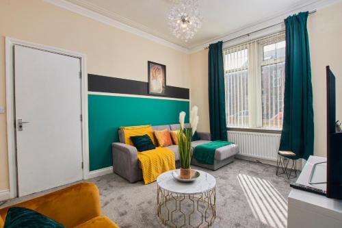 a living room with a couch and a table at Sleek House - 5 Minutes From Newcastle City Centre in Newcastle upon Tyne