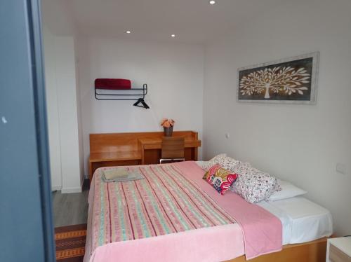 Un dormitorio con una cama con una manta rosa. en Vista Funchal Ⅰ, en Funchal