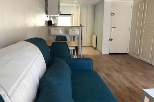 sala de estar con sofá azul y mesa en Suites Rive Gauche - FONTAINEBLEAU - Chez Julien en Fontainebleau
