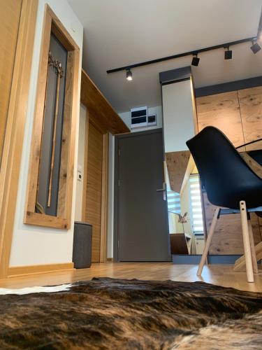 a room with a black chair and a door at Apartman Kiš Kraljevi Čardaci in Kopaonik