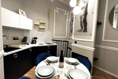 une petite cuisine avec une table et des chaises bleues dans l'établissement Palais Royal - Chez Lucas, à Paris