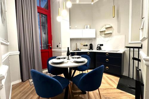 巴黎的住宿－Palais Royal - Chez Lucas，一间厨房,内设一张桌子和蓝色的椅子