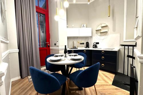 - une cuisine avec une table et des chaises bleues dans la chambre dans l'établissement Palais Royal - Chez Lucas, à Paris