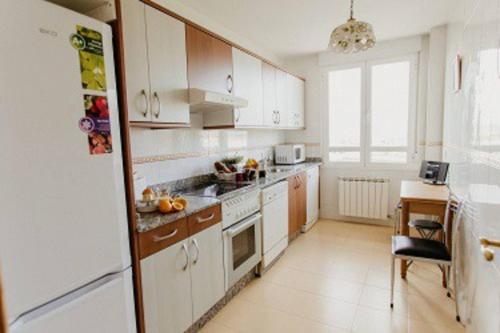 a kitchen with white cabinets and a white refrigerator at Cozy Apartment Ponferrada 109 m², Parking in Ponferrada