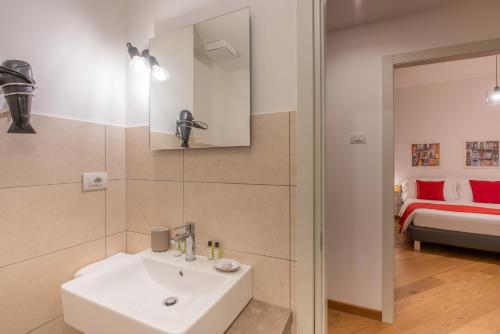 a bathroom with a white sink and a bed at U Genova in Genoa