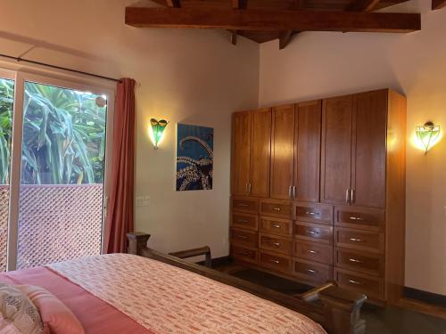 a bedroom with a bed and a dresser and a window at Casa Maya in West Bay