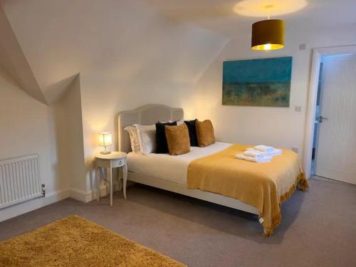 a bedroom with a large bed with a yellow blanket at Pass the Keys Bright Spacious Chilterns Hideaway in Saunderton