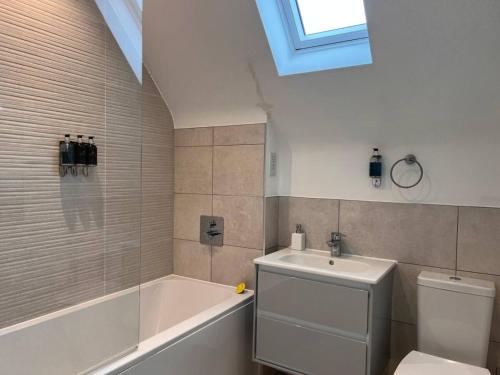 a bathroom with a tub and a toilet and a sink at Pass the Keys Bright Spacious Chilterns Hideaway in Saunderton