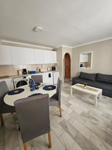 cocina y sala de estar con mesa y sofá en APARTAMENTO VERA COAST 123, en Playas de Vera