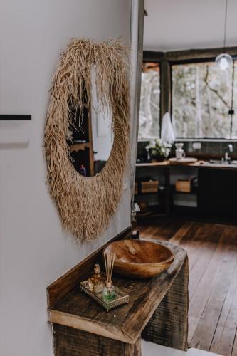 a bathroom with a wooden bowl on a table with a mirror at Casablanca Villas CB in Brumadinho