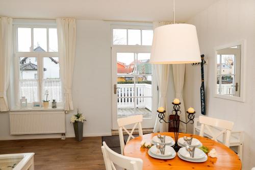 a dining room with a table and a lamp at Villa Zur Alten Post in Kühlungsborn