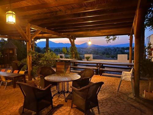 a patio with a table and chairs under a wooden pergola at La Granja de Antonio in Alhaurín el Grande