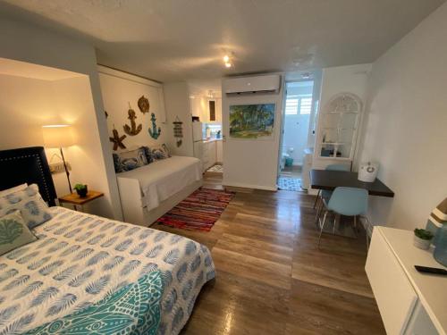 Schlafzimmer mit einem Bett, einem Tisch und einem Schreibtisch in der Unterkunft KASA Ocean Breeze - Cabana Studio Apartment BEACHFRONT CONDO POOL in San Juan
