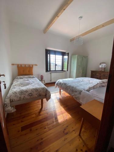 a bedroom with two beds and a wooden floor at Casale del Passatore sas in Rocchette