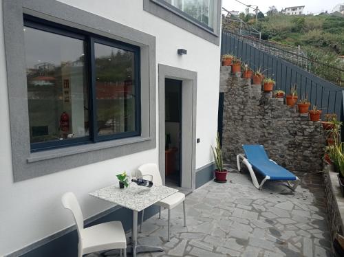 a patio with a table and chairs next to a building at Vista Funchal Ⅰ in Funchal