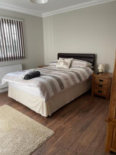 um quarto com uma cama grande e piso em madeira em OAK LODGE em Tillingham