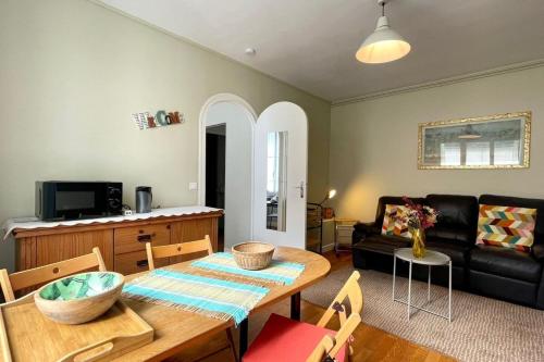 un salon avec une table et un canapé dans l'établissement Fontainebleau - Chez Marguerite, à Fontainebleau