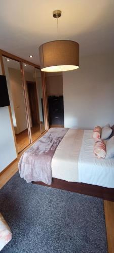 um quarto com uma cama grande e uma luz em Piso céntrico al lado de Oviedo em Lugones