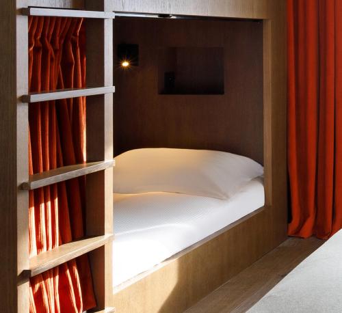 a bedroom with a bed in a built in closet at Ours Blanc Hotel & Spa in Les Menuires