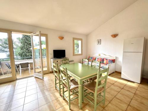 sala de estar con mesa verde y sillas en Parc et Résidence le Provençal, en Hyères
