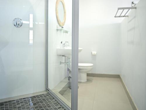 a bathroom with a toilet and a glass shower at Atlantic Oasis Guest House in Table View