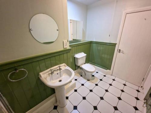 a bathroom with a sink and a toilet and a mirror at Canal Street Apartment in Manchester