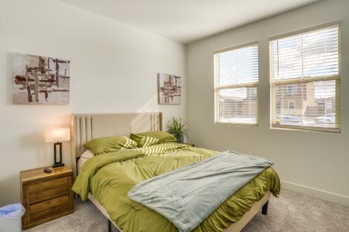 a bedroom with a bed with a green comforter at Newly Built Glendale Home 5 Mi to Westgate! in Glendale