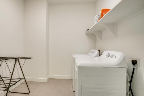 a white laundry room with a sink and a staircase at Newly Built Glendale Home 5 Mi to Westgate! in Glendale