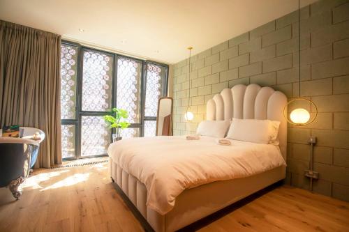 a bedroom with a large white bed and windows at Luxury Roof Terrace Townhouse in Manchester
