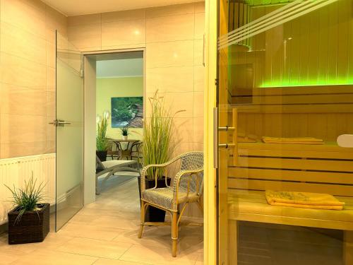 a hallway with a chair and a glass door at Landhaus Müritzgarten Hotel garni in Röbel