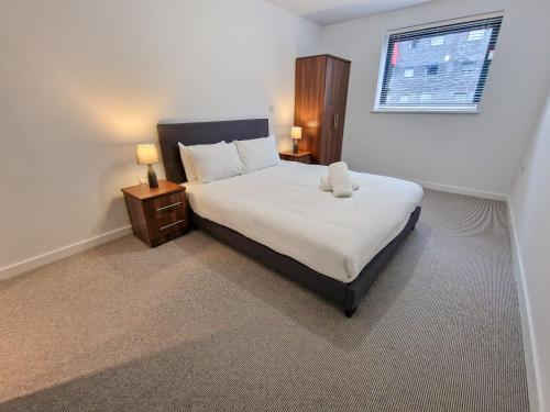 a bedroom with a large bed and a window at Free Parking - Stunning Canal Facing Apartment in Manchester