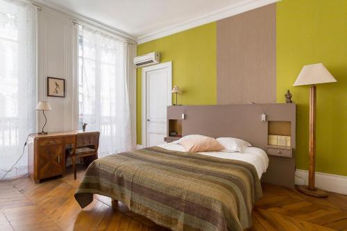 - une chambre avec un lit, un bureau et des murs verts dans l'établissement Hamac Suites - Suite Albon Saint Antoine - 4pers, à Lyon