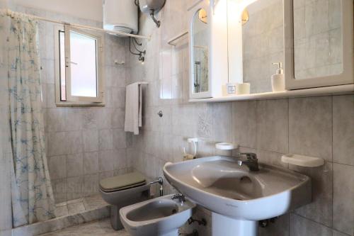 a bathroom with a sink and a toilet at Villette Torre Pali by LoveSud in Torre Pali 