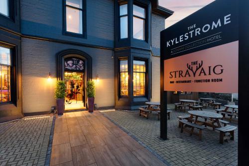 a building with benches and a sign in front of it at The Kylestrome in Ayr