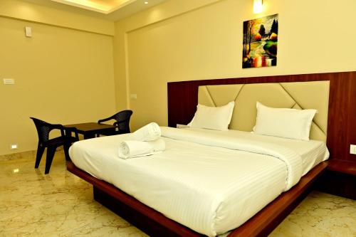 a hotel room with a bed and a table at DOWNTOWN PR Groups Raashi Residency in Channarāyapatna