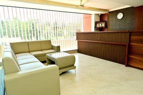 a waiting room with two couches and a reception desk at DOWNTOWN PR Groups Raashi Residency in Channarāyapatna