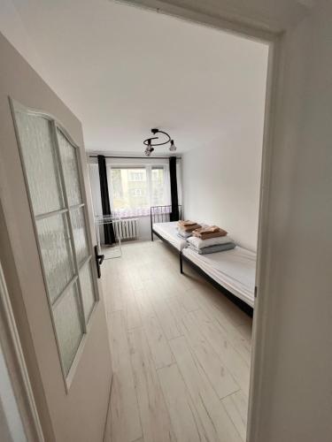 プシェムィシルにあるmieszkanie 2 pokoje, Przemyśl, parterのベッド1台、窓、ドアが備わる客室です。