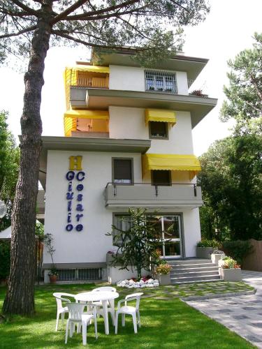 a building with tables and chairs in front of it at Hotel Giulio Cesare in Cinquale