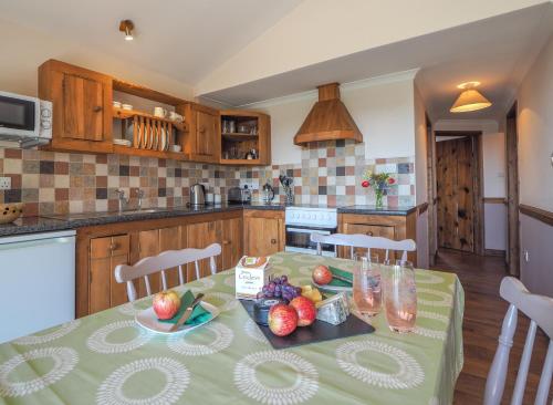 a kitchen with a table with fruit on it at Caban Cynnes in Troedyraur