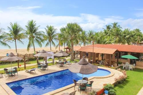 ein Luftblick auf ein Resort mit einem Pool und Palmen in der Unterkunft Pousada Coqueiro Verde in Japaratinga