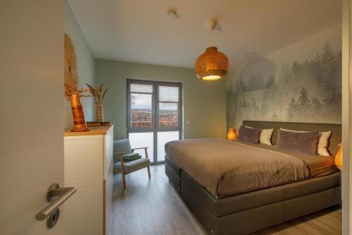 a bedroom with a large bed and a window at Lindenberg Apartments in Wernigerode