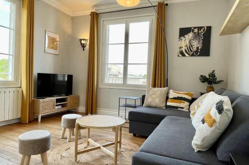 a living room with a couch and a tv at Suites Rive Gauche - Région Fontainebleau - Chez Victor in Melun