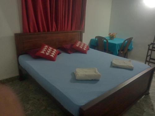 een slaapkamer met een bed met rode en witte kussens bij Homefeel in Katunayaka