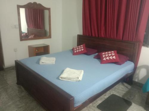 een slaapkamer met een bed met twee handdoeken erop bij Homefeel in Katunayaka
