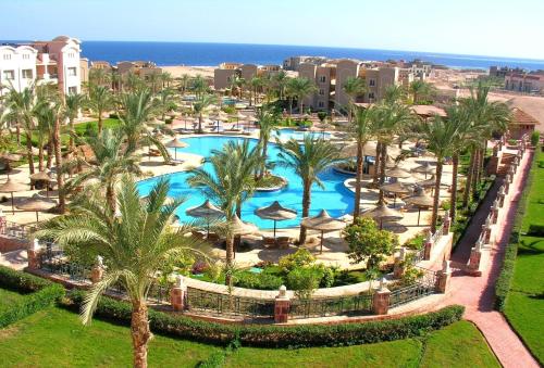 an aerial view of a resort with a pool and palm trees at Pyramisa Sunset Pearl Apartments in Hurghada