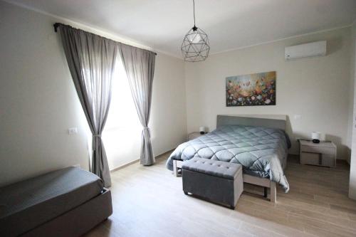 a bedroom with a bed and a couch and a window at La Valle B&B in Castel Campagnano