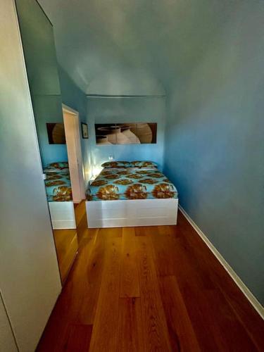 two beds in a blue room with wooden floors at Casa nonna Mimma in Narni