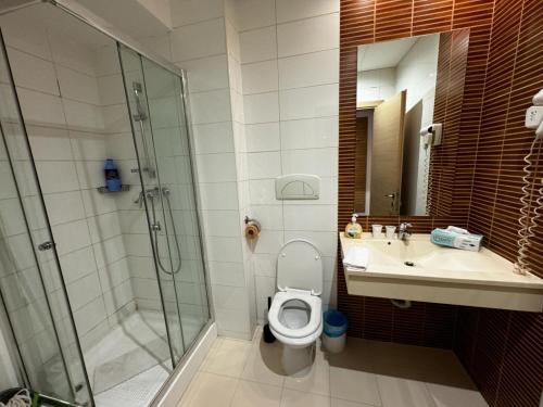 a bathroom with a shower and a toilet and a sink at Romance Suites in Bucharest