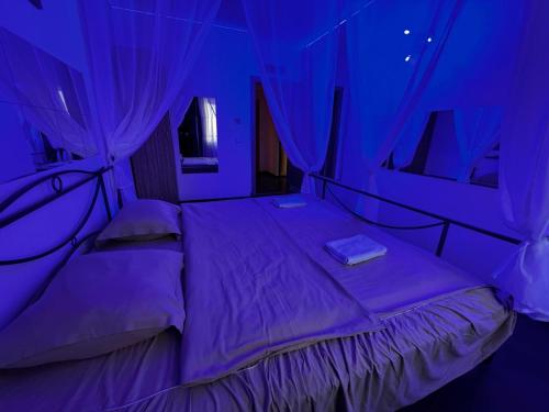 a bed in a room with purple lighting at Romance Suites in Bucharest