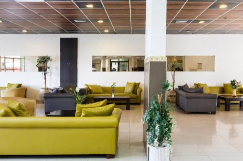 a lobby with couches and tables in a building at מלון המלך שאול in Ashqelon
